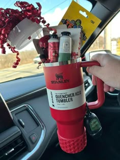 a person holding a cup filled with items in their hand while sitting in a car