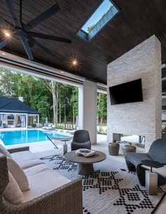 a living room filled with furniture next to a swimming pool