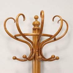 an ornate wooden coat rack on a white wall