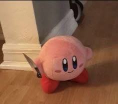 a pink stuffed animal with a knife stuck in it's back end on the floor