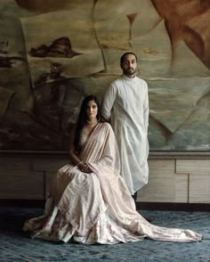 a man and woman posing in front of a painting