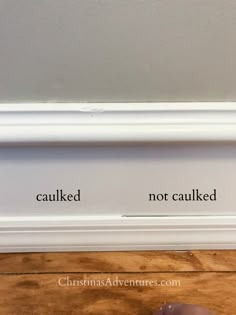 a close up of a mouse on a wooden floor next to a wall with the words caulked and not caulked