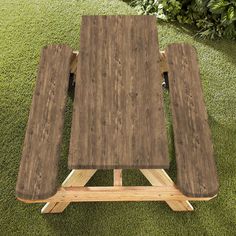 a picnic table made out of wooden planks in the grass with wheels attached to it