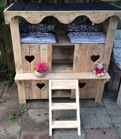 a wooden bench with two stools on top of it and a small ladder to the side