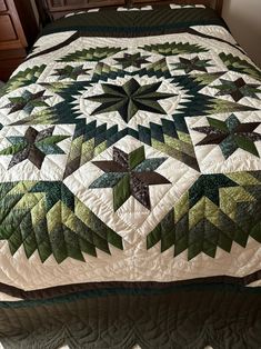 a bed with a green and white quilt on it