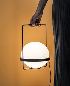 a person is holding a lamp in their hand