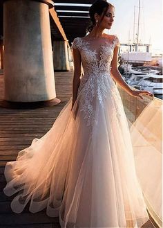 a woman in a wedding dress standing on a dock