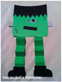 an image of a paper cut out of a green monster with black hair and eyes