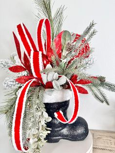 a snow boot with red and white ribbon on it sitting on top of a table