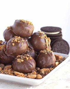 chocolate covered cookies stacked on top of each other in a white square plate next to oreos