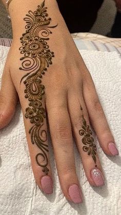 a woman's hand with henna tattoos on it