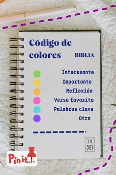 a spiral notebook sitting on top of a white sheet with colorful writing in spanish and the words cosigo de colores