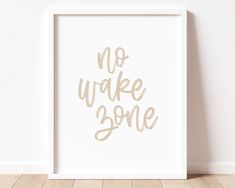 a white framed poster with the words no wake some in gold foil lettering on it