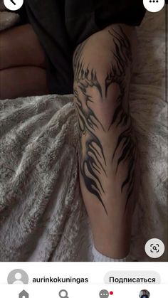 a person laying on top of a bed with a tattoo on their arm and leg