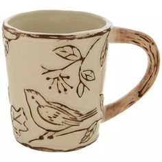 a coffee mug with birds painted on the side and brown trim around the bottom, sitting in front of a white background