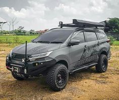 an suv parked on the side of a dirt road