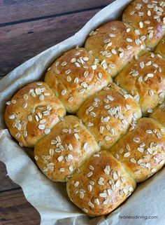 a baking pan filled with bread rolls covered in sesame seeds