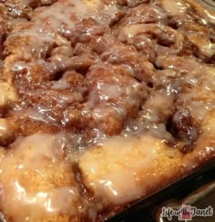 a casserole dish with cinnamon rolls and icing on top, ready to be eaten