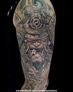 a man's arm with tattoos on it and an image of a demon in the background