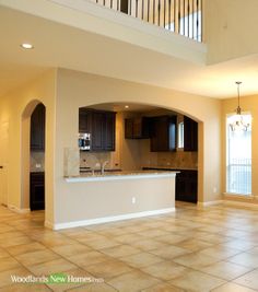 an empty kitchen and living room in a new home with tile flooring on the floor