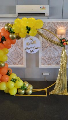 a balloon arch decorated with gold and orange balloons