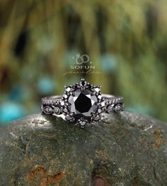 a black diamond ring sitting on top of a rock