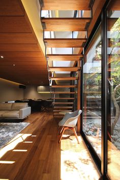 the inside of a modern house with wood floors and glass doors leading to an outside deck