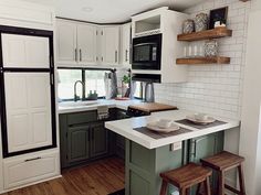 a kitchen with green cabinets and white counter tops