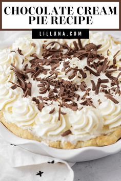 a chocolate cream pie with whipped cream and chocolate sprinkles on top in a white dish