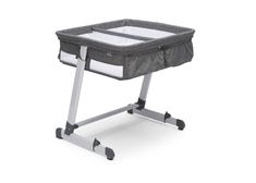 a baby crib that is on wheels and has a gray cover over the top