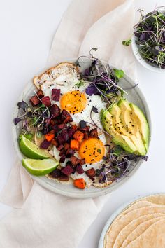 a plate with eggs, avocado, carrots and other food on it