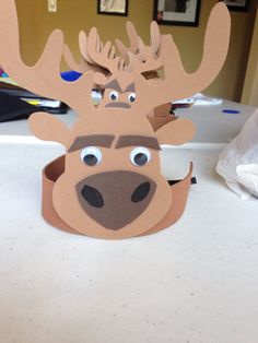 a paper cup that has a moose head on it, and is sitting on top of a table