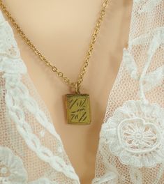 Sweet petite two picture locket. Size: 1/2" high x 3/8" wide (12mm x 9mm) rectangular locket with Art Deco style etchings.  Inside shows original removable frames to hold pictures in place. Openings measure 3/8" high x 1/4" wide. Locket slides easily on a gold finished fine 16" (406mm) curb chain, with well functioning spring ring closure. Overall locket and chain in nice condition, with minimal signs of wear. Small book locket gift for an adult, a child or for doll jewelry. Here are some other Vintage pendants: www.etsy.com/listing/1708616525; www.etsy.com/listing/1089618546; www.etsy.com/listing/1506860650; www.etsy.com/listing/1481561310; www.etsy.com/listing/1699651785; www.etsy.com/listing/919029826; www.etsy.com/listing/1058513988; www.etsy.com/listing/219429243; www.etsy.com/listing 50 Anniversary, Picture Locket, Book Locket, Memory Locket, Doll Jewelry, Art Deco Necklace, Gold Tone Necklace, Memorial Gifts, Necklace Gift