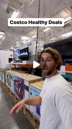 a man standing in front of a counter with lots of items on it and the caption costco healthy deal