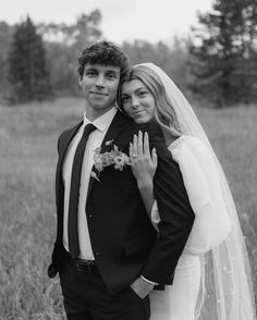 a bride and groom posing for a photo in the middle of a field with tall grass