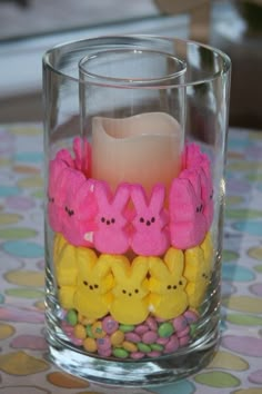 a candle is sitting in a glass filled with peep - poop candies