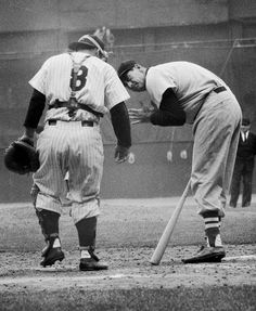 two baseball players standing next to each other on a field