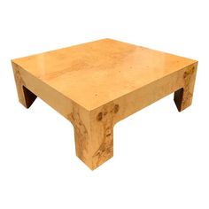 a square wooden table sitting on top of a white floor