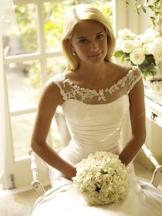 a woman in a wedding dress holding a bouquet