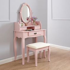 a pink vanity table with a mirror and stool