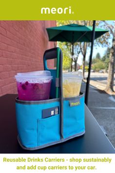 a blue bag with drinks in it sitting on top of a table next to an umbrella