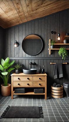 a bathroom with black walls and wood accents, including a round mirror above the sink