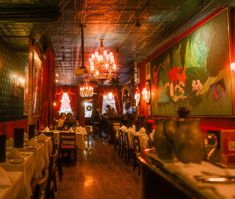 an empty restaurant with tables and chandeliers