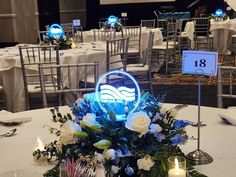 a centerpiece with flowers and candles is displayed on a round table in the middle of a banquet hall