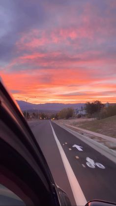 the sun is setting on an empty highway