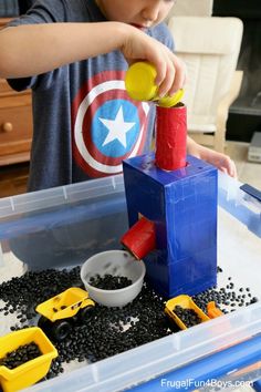 a young boy playing with toys in a plastic container