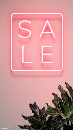 a pink neon sign that says sale next to a potted plant