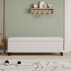 a white bench sitting in the middle of a living room next to a green wall