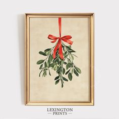 a painting hanging on the wall with a red ribbon around it's neck and green leaves