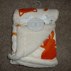 an orange and white blanket laying on the floor